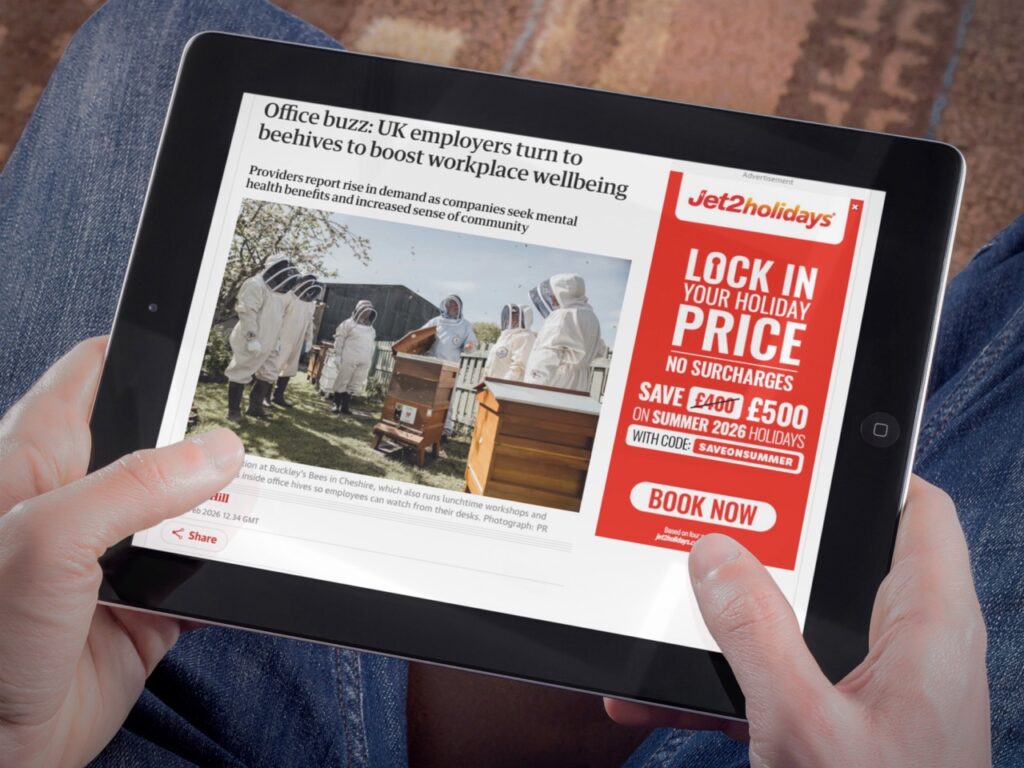 The article Office buzz: UK employers turn to beehives to boost workplace wellbeing from The Guardian displayed on an iPad.
